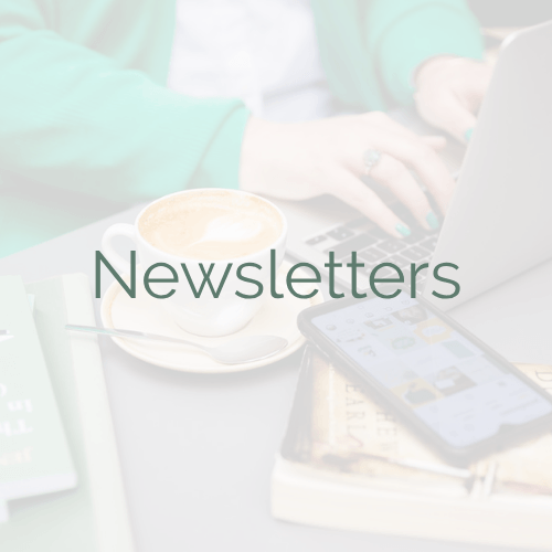 'Newsletters' in green text on a semi-transparent white background. Under the semi-transparent layer is a photo of my hands and torso as I type on a laptop at a cafe. There's a cup of coffee, some books, and my smartphone next to the laptop.